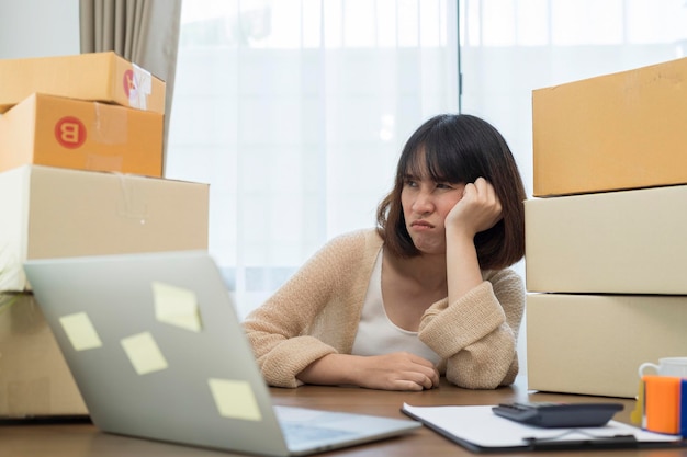 El estrés de los jóvenes empresarios asiáticos en el fracaso de los negocios en línea, la mujer con un problema de trabajo, el empresario de PYME y el concepto de venta en línea