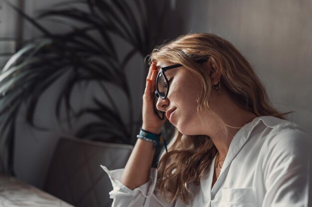 Estresada mujer cansada con dolor teniendo un fuerte ataque de dolor de cabeza terrible después de la computadora portátil