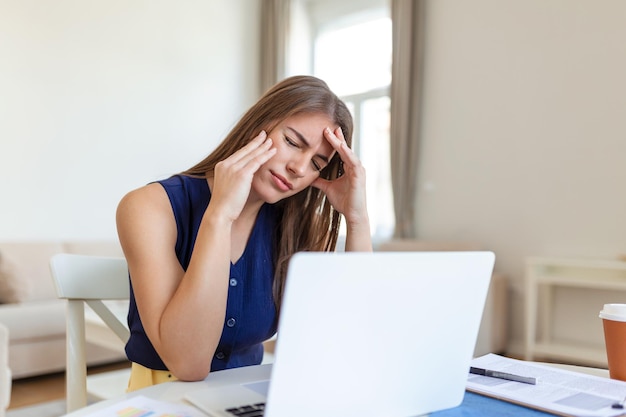 Estresada mujer de negocios cansada se siente agotada sentada en el escritorio de la oficina con la computadora portátil y el papel arrugado mujer frustrada no puede concentrarse teniendo escritores bloquean la falta de nuevas ideas o crisis creativa