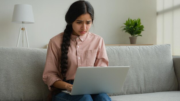 Foto estressada mulher árabe mulher de negócios estudante freelancer lendo más notícias olhando para o laptop receber