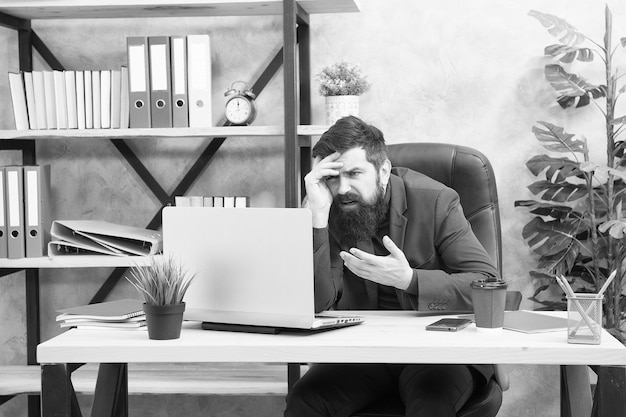 Estressado do empresário de trabalho com roupa formal homem estressado usa laptop trabalho de chefe no local de trabalho homem barbudo estressado trabalha no escritório se sentindo estressado depois do trabalho homem muito ocupado