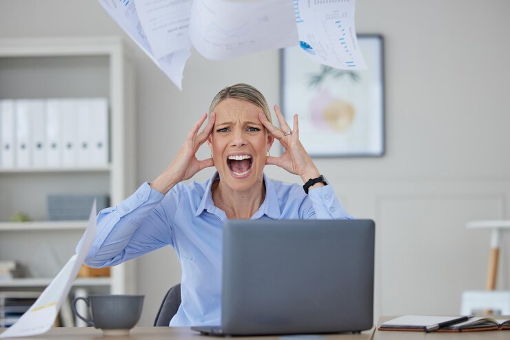 Foto estresse com raiva e mulher gritando em sua mesa de escritório em frustração e medo em problemas de trabalho raiva de pânico grave ou dor de cabeça por notícias sobre imposto de auditoria ou falência enquanto estava no trabalho corporativo