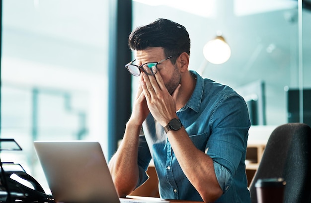 Foto estresse de dor de cabeça e homem de negócios cansado no laptop no escritório para crise de dívida de ansiedade e problema de fadiga ocular fadiga de burnout e trabalhador no computador com nevoeiro cerebral de dor e frustrado com o erro