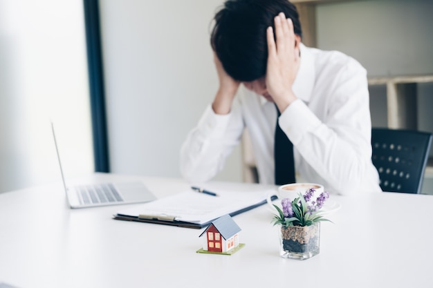 Foto estresse de homem de negócios frustrado quando falhar com agente imobiliário trabalho enquanto está sentado na mesa