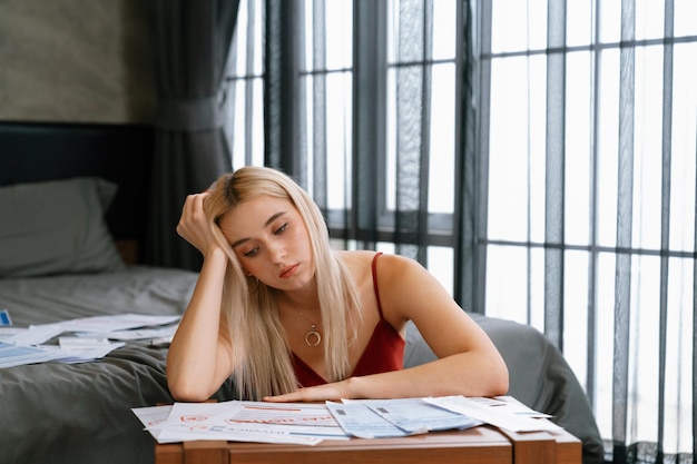 Foto estresse jovem mulher sentar-se na mesa pagar dívida de cartão de crédito blithe