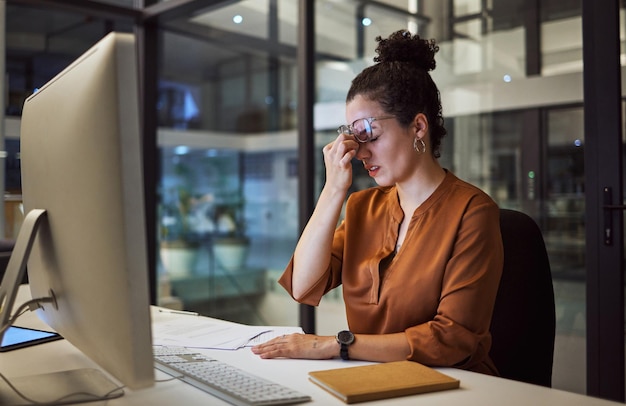 Foto estresse mulher de negócios cansada e frustrada trabalhando em um computador na mesa em seu escritório dor de cabeça de burnout e gerente corporativo planejando um relatório de estratégia de gerenciamento da empresa com tecnologia