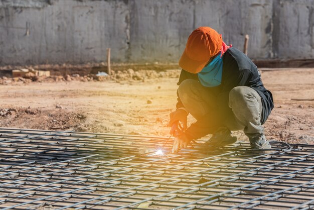 Estructura de acero de soldadura en sitio de construcción con luz del sol