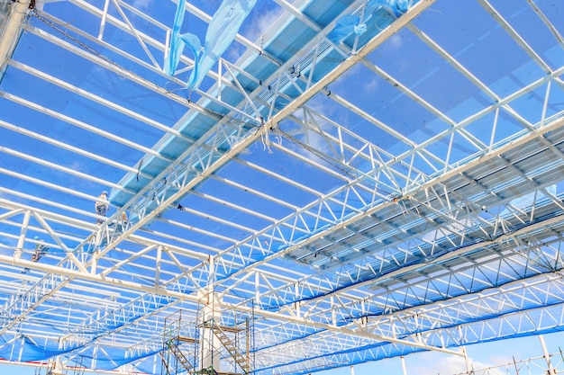 Estructura del bastidor de acero del tejado para la construcción de edificios en fondo del cielo azul.