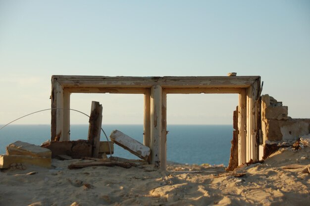 Estructura construida abandonada en la playa contra un cielo despejado