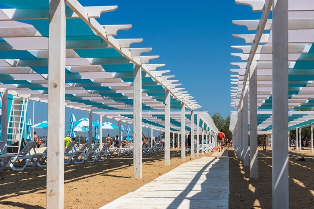 Estructuras arquitectónicas de madera y tumbonas blancas en la playa del mar negro