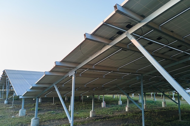 Estrutura de aço com base no solo de uma grande usina elétrica sustentável com fileiras de painéis solares fotovoltaicos para a produção de energia elétrica ecológica limpa.