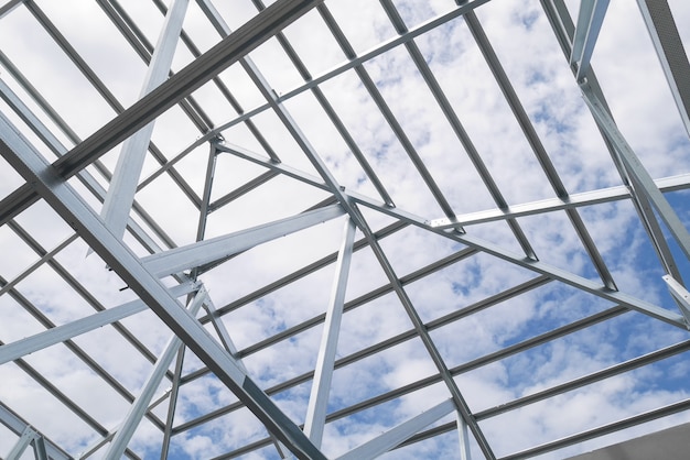 Foto estrutura de armação de telhado de aço com céu azul e nuvens no canteiro de obras