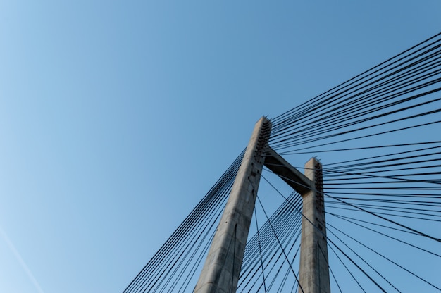 Foto estrutura moderna do pilão da ponte do cimento sobre o céu azul claro.