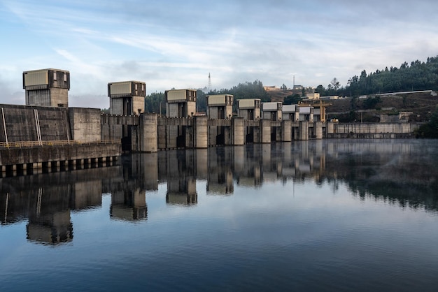 Estrutura sólida da barragem de Crestuma Lever no rio Douro em Portugal refletida em águas calmas