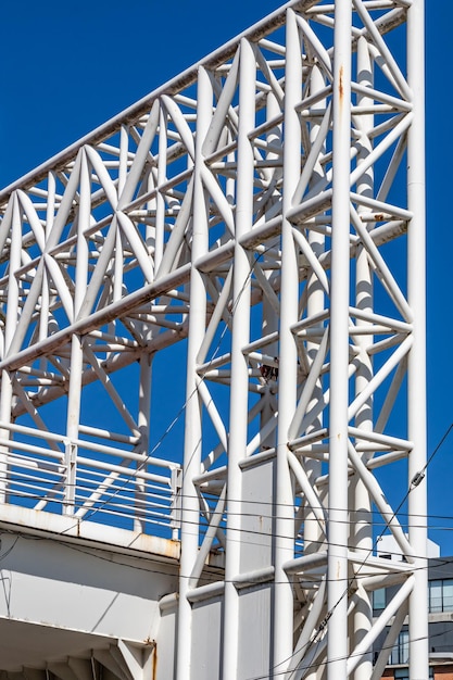 Foto estrutura tubular branca quadrada de uma ponte pedonal que está sobre uma avenida com muito tráfego de veículos contra um céu azul claro dia ensolarado em zapopan jalisco méxico