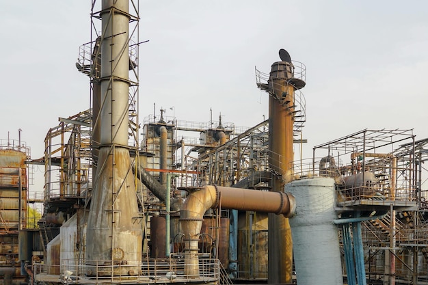 Estruturas metálicas da antiga fábrica Planta industrial com velhos tubos enferrujados e torre de resfriamento