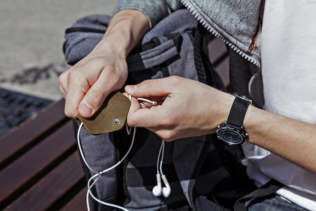 Estuche de cuero para auriculares en primer plano de manos de hombres