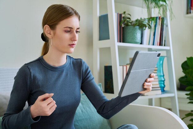 Estudante adolescente em casa olhando para a câmera web do tablet digital