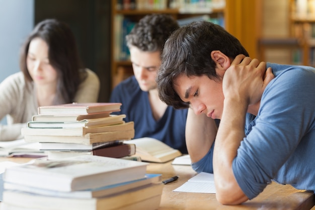Estudante adormecendo na biblioteca