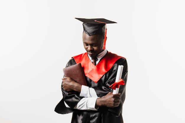 Estudante africano confiante com diploma em manto de formatura e boné pronto para terminar a faculdade Futuro líder da ciência Acadêmico homem africano em vestido preto sorrindo