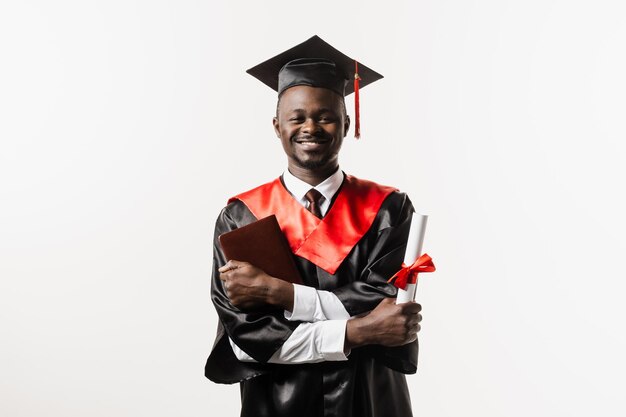 Estudante africano confiante com diploma em manto de formatura e boné pronto para terminar a faculdade Futuro líder da ciência Acadêmico homem africano em vestido preto sorrindo