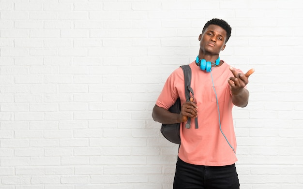 Foto estudante afro-americano novo do homem que faz o gesto do chifre. expressão negativa