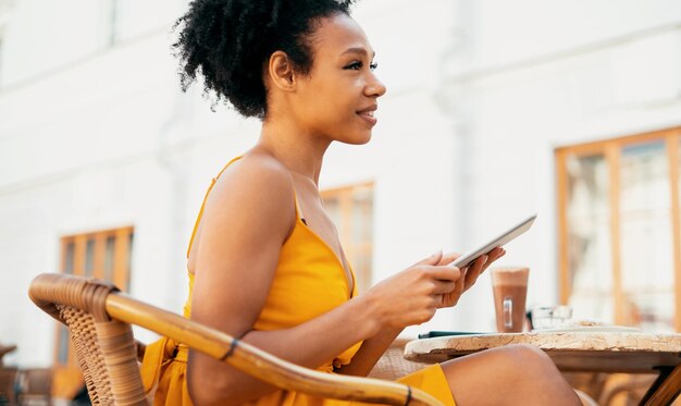 Estudante aprendendo em um tablet para navegar na internet em um café Mulher comprando roupas online