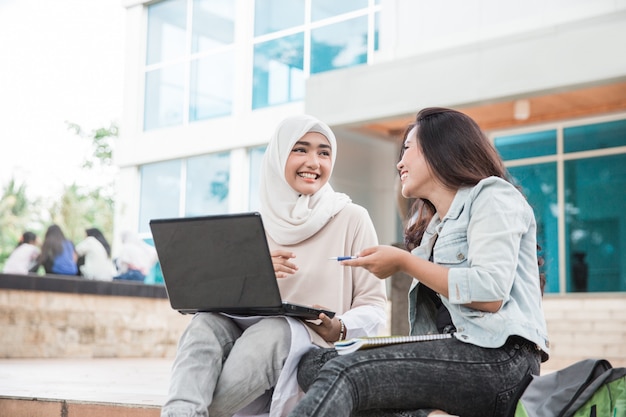 Estudante asiática dois usando laptop