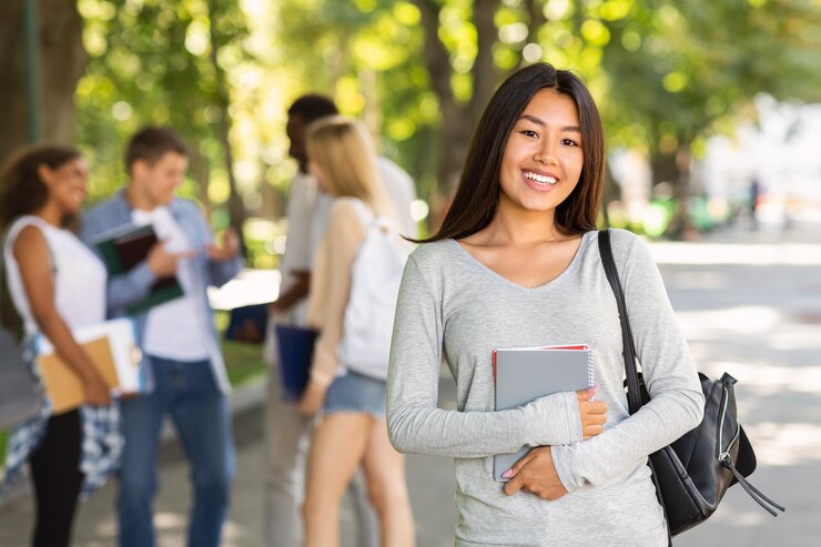 Foto estudante asiática feliz a sorrir para a câmara.
