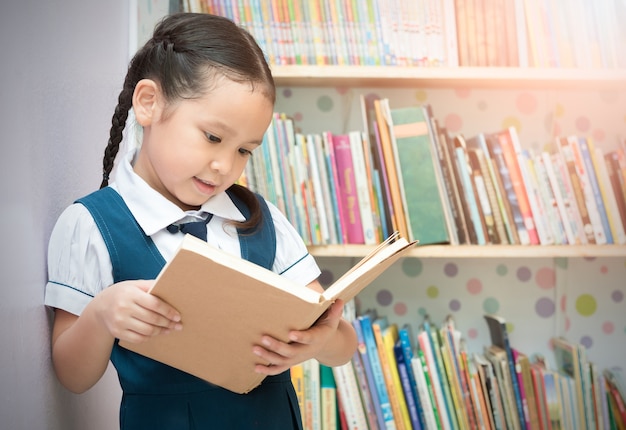 estudante asiática linda garota lendo livro na biblioteca