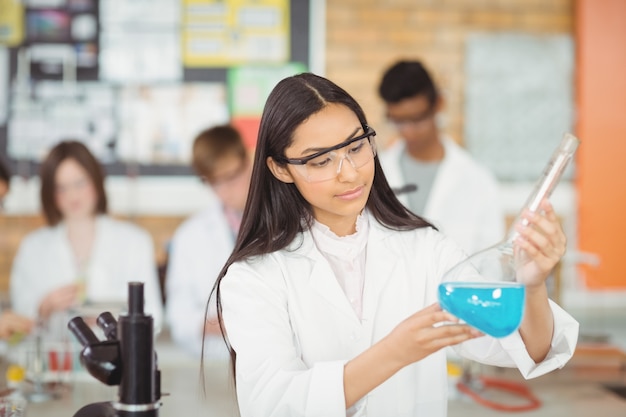 Estudante atenta fazendo um experimento químico em laboratório