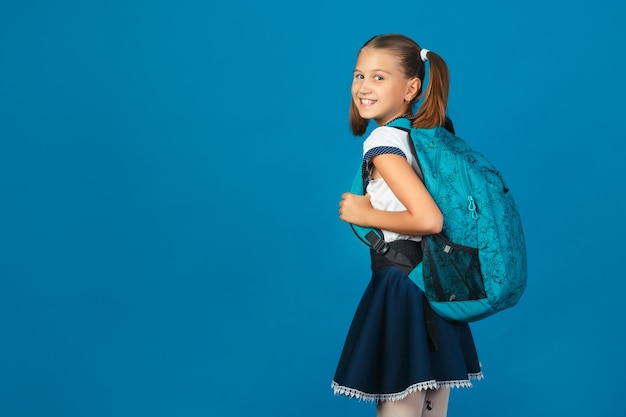 Estudante bonito com mochila azul olhando