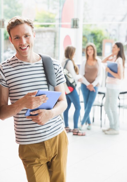 Estudante bonito sorrindo e segurando comprimido