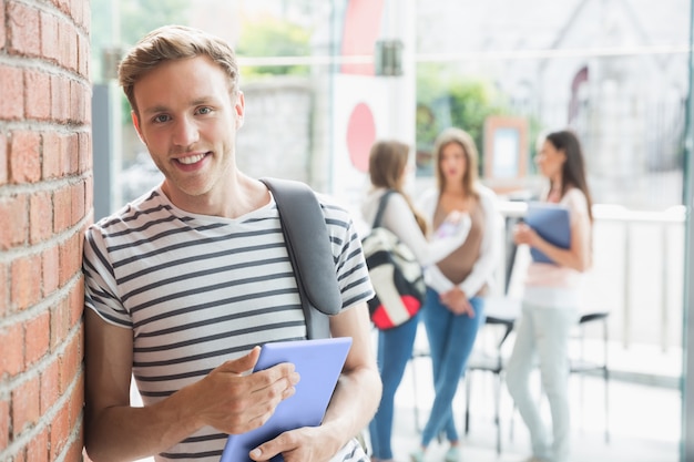 Estudante bonito sorrindo e segurando comprimido