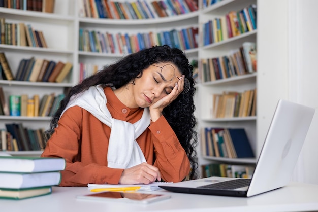 Foto estudante cansada adormeceu enquanto estudava sentada na mesa em frente ao laptop cansada.