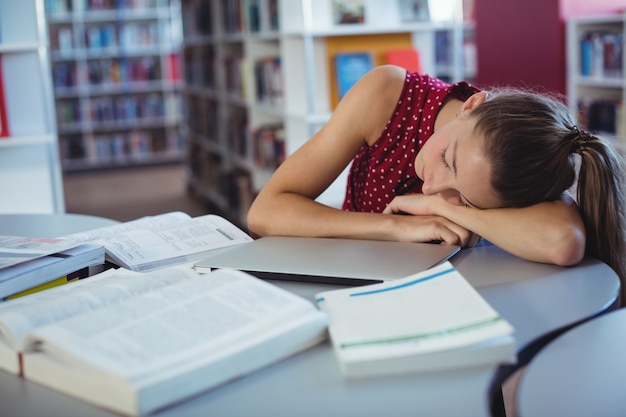 Foto estudante cansada dormindo enquanto estudava na biblioteca