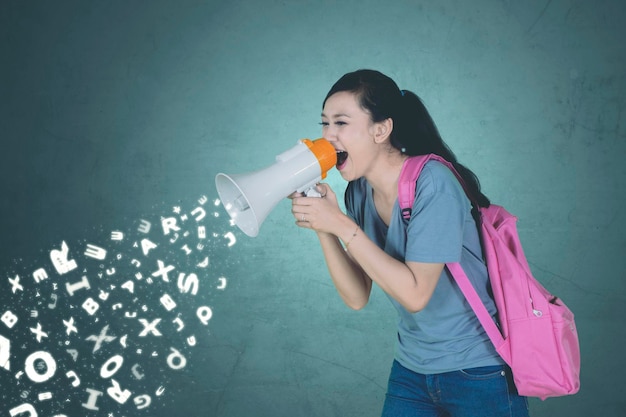 Estudante caucasiano gritando através de um megafone