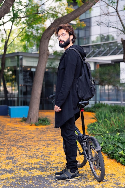 Estudante com bicicleta dobrável no campus universitário