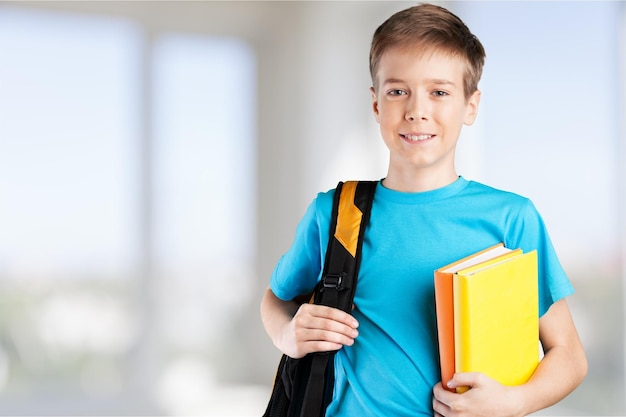 Estudante com livros e mochila sorrindo para a câmera