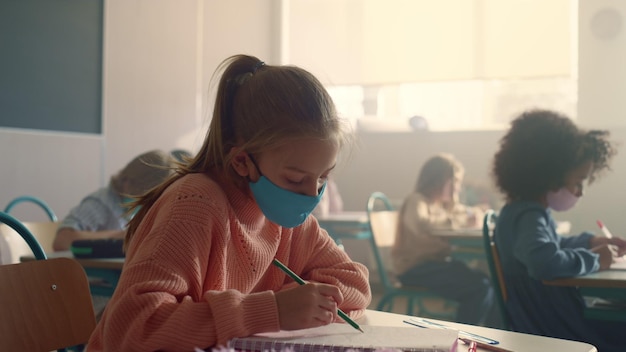 Estudante com máscara de proteção estudando na escola durante a pandemia de coronavírus