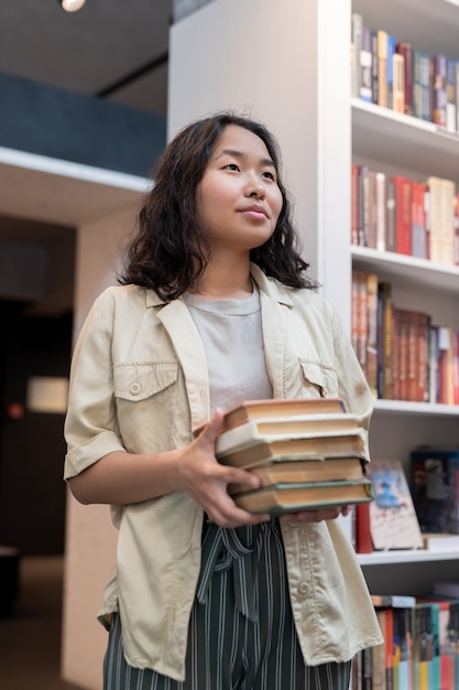 Estudante contemporâneo com pilha de livros