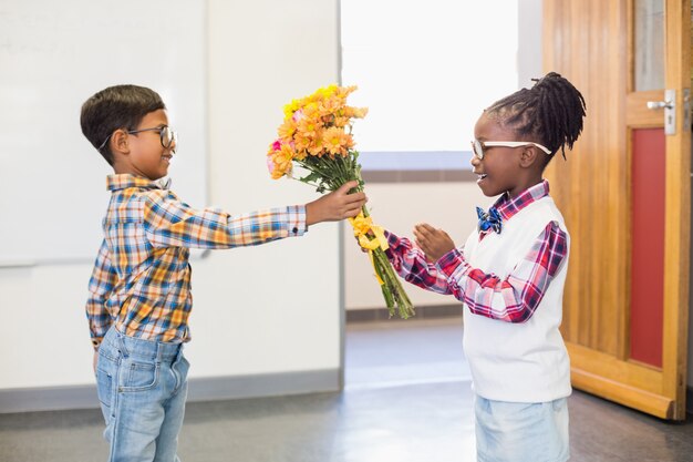 Estudante dando um ramo de flores para uma menina