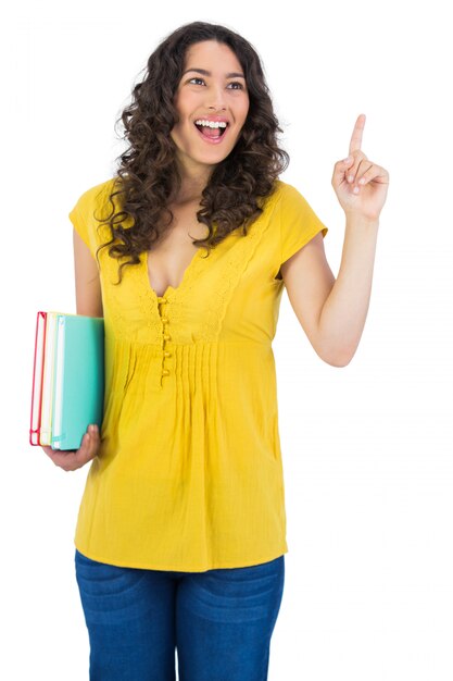 Foto estudante de cabelo encaracolado feliz segurando os cadernos