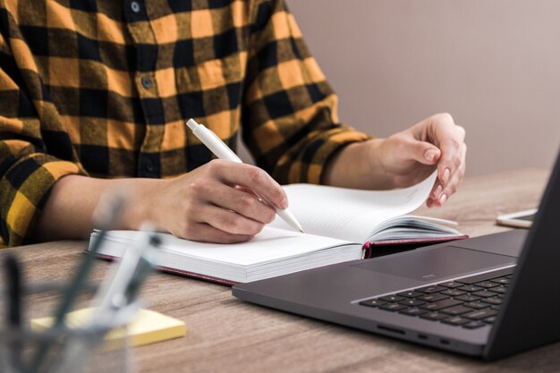 estudante de camisa amarela, fazendo anotações em seu caderno