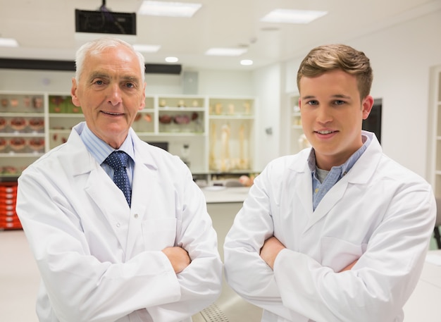 Estudante de ciência e professor sorrindo para a câmera