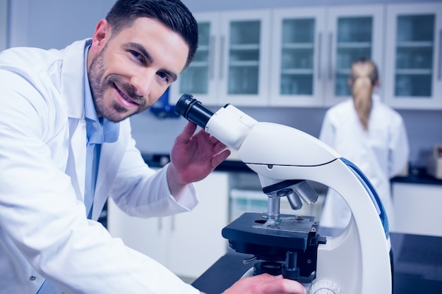 Estudante de ciência trabalhando com microscópio no laboratório