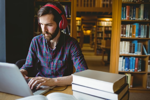 Estudante de Hipster estudando em biblioteca