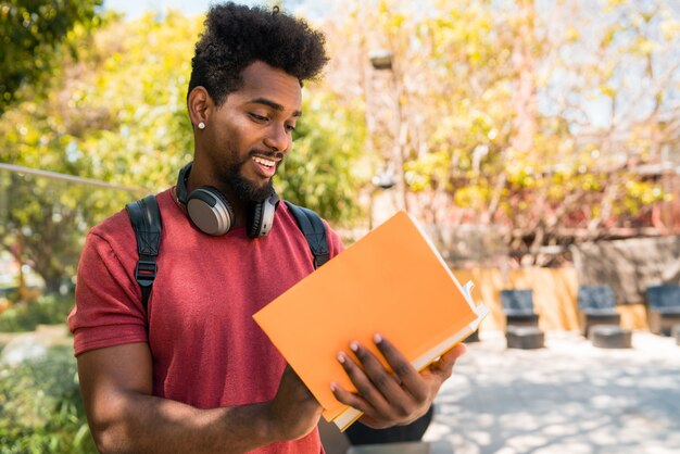 Estudante de homem afro estudando e lendo seu livro.