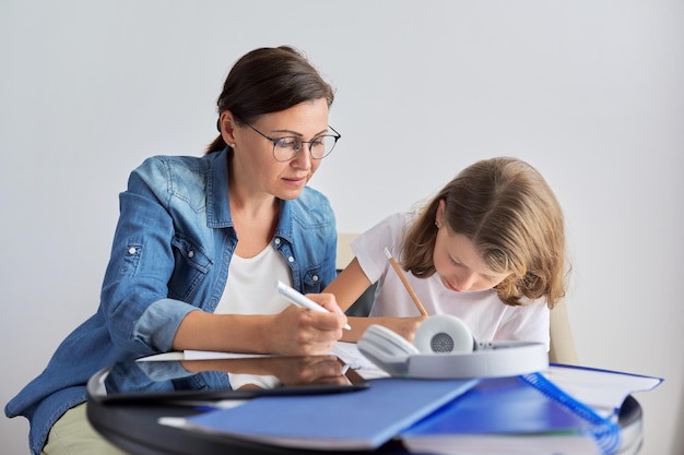 Estudante de mãe e filha aprendendo lições escolares juntos em casa