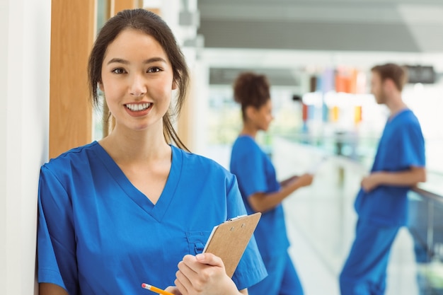 Estudante de medicina sorridente na câmera no corredor